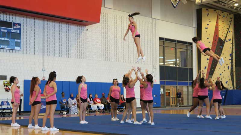 Cheerleading squad Cheerleading squad throws two team members in the air in SHS field house